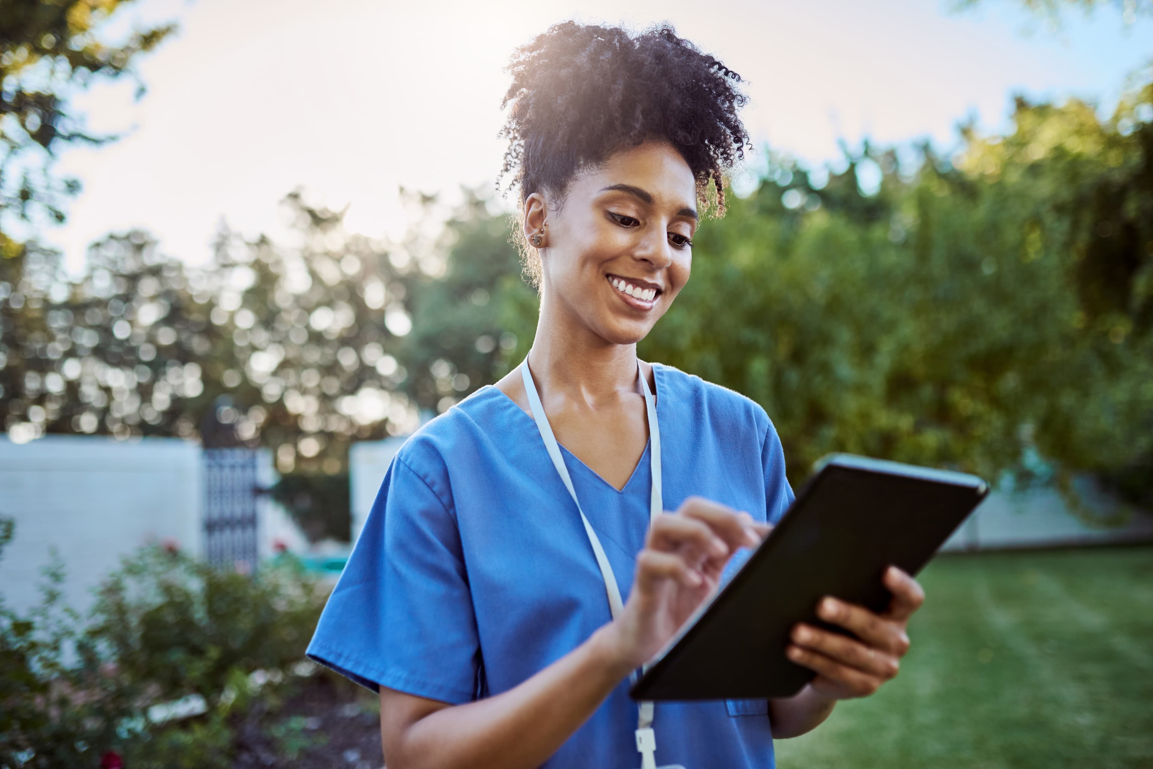 Medical nurse, caregiver and digital tablet for test results, physiotherapy schedule and nursing home consulting calendar. Smile, happy and technology for working physiotherapist in Brazilian garden